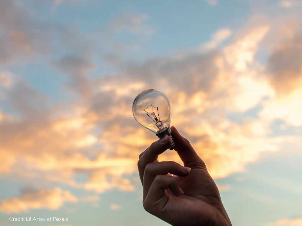 A hand holding a light bulb symbolising innovative military power management solutions